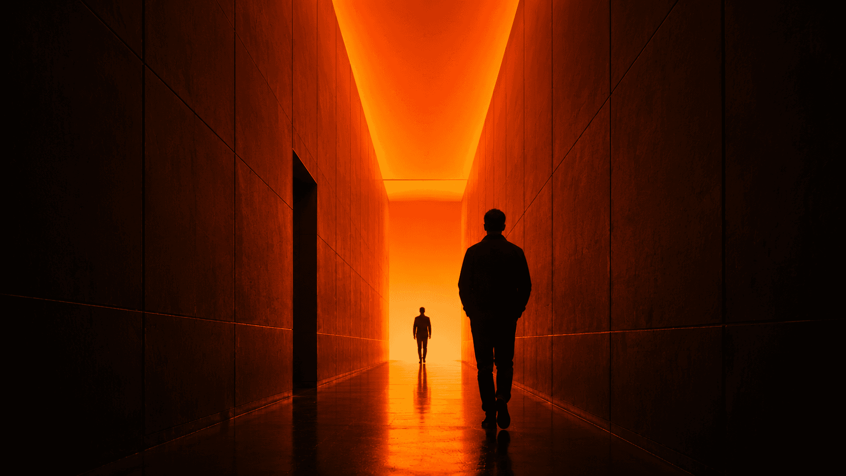 A figure walking down a corridor lit in deep orange