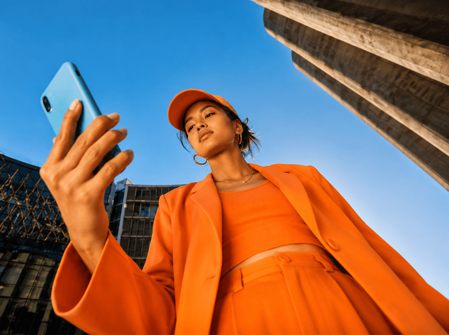 A person on a phone against a bright sky